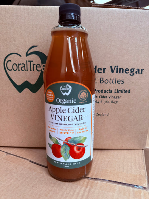A bottle of CoralTree Organic Apple Cider Vinegar placed in front of a branded cardboard shipping box.